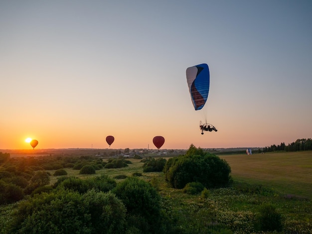 Globo de aire colorido está volando en vuelo libre sobre el campo Globo multicolor en el cielo al atardecer