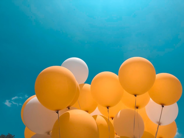 Globo amarillo y blanco con fondo azul.