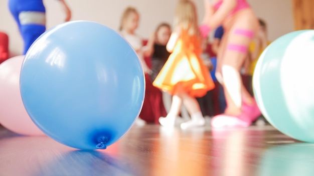 Globo azul y grupo de niños desenfocados en el fondo