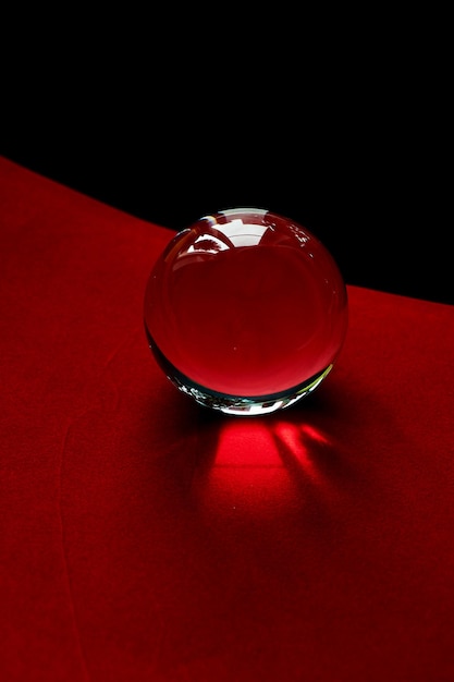 Globo de cristal o gota de agua sobre un fondo de papel de terciopelo rojo y negro Limpiar y brillar