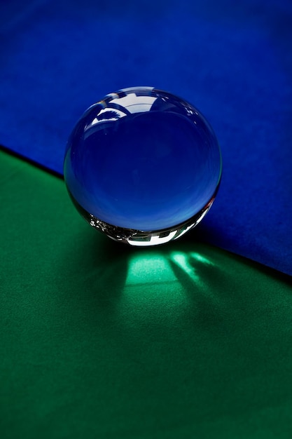 Globo de cristal o gota de agua sobre un fondo de papel de terciopelo verde y azul Limpiar y brillar