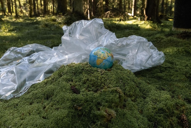 globo e floresta verde de filme plástico, poluição do meio ambiente. O problema da reciclagem do plástico