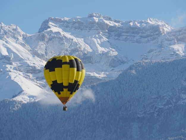Foto globo negro y amarillo con la montaña nevada en la parte posterior