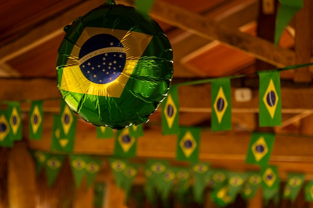 Foto globo pequeño y banderitas de papel todas estampadas con la bandera de brasil