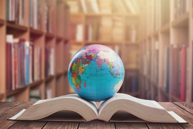 Un globo sobre un libro abierto con el telón de fondo de las estanterías de una biblioteca.