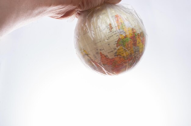 Globo terráqueo en una bolsa de plástico aislada sobre fondo blanco