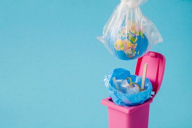 El globo terráqueo se encuentra en la basura. El mundo yace en un montón de plástico.