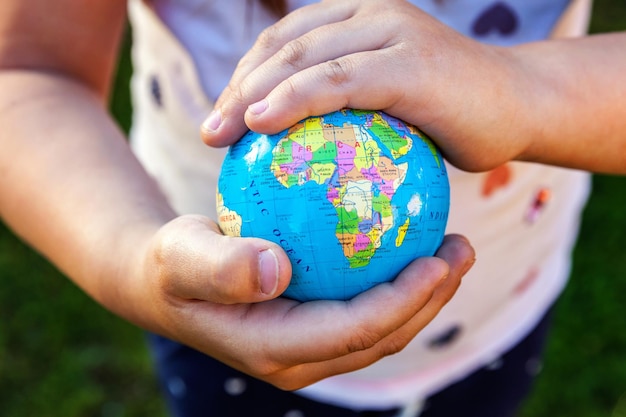 Globo terráqueo en manos de niños