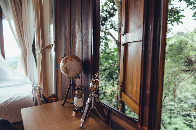 Globo terráqueo sobre una mesa de madera en una casa de maderaViaja por el mundo