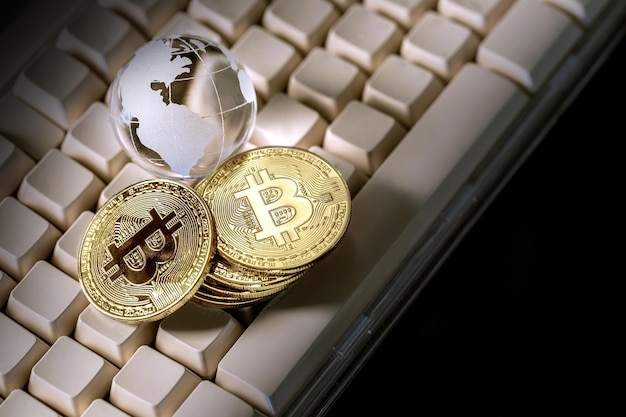 Globo de vidrio y criptomoneda bitcoin en el concepto de negocio del teclado