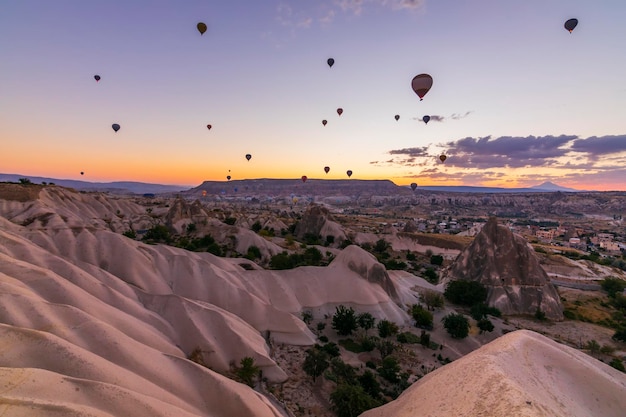 Foto globos aerostáticos volando sobre un paisaje volcánico en cappadocia turquía