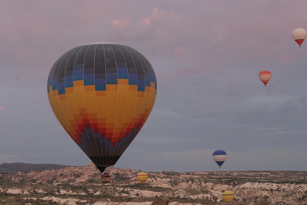 Globos de aire coloridos flotan en el cielo sobre el valle de la montaña al amanecer capadocia tradicional