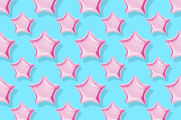 Globos de aire de papel en forma de estrella sobre fondo en colores pastel