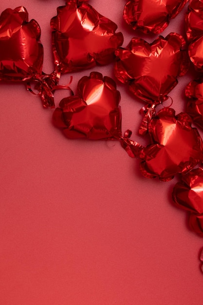 Globos de aluminio en forma de corazón en una vista superior de fondo rojo. Copie el espacio. Fondo festivo para el día de San Valentín