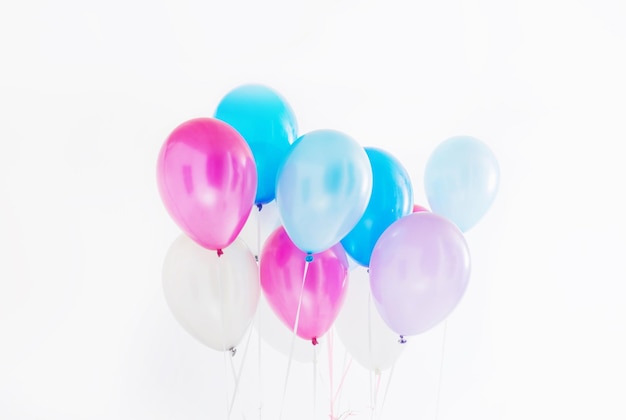 Foto globos azules y rosas sobre fondo blanco.