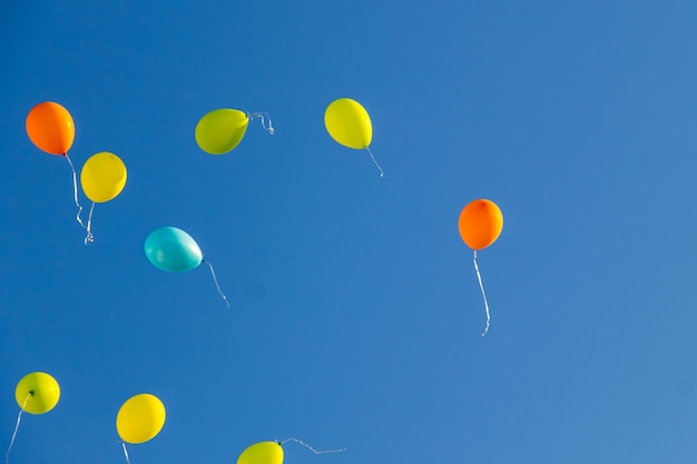 Globos de colores volando en el cielo azul