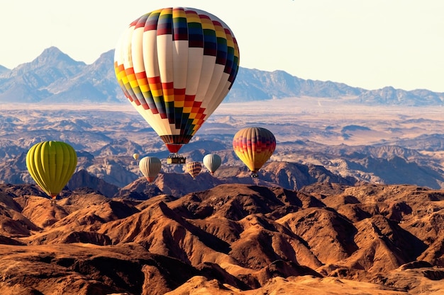 Globos de colores volando sobre la montaña del valle de la luna. África. Namibia.