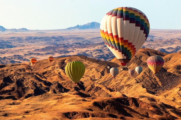 Globos de colores volando sobre la montaña del valle de la luna. África. Namibia.