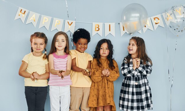 Globos y confeti Los niños que celebran la fiesta de cumpleaños en el interior se divierten juntos