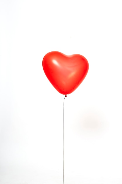 Foto globos de corazón rojo sobre un fondo blanco