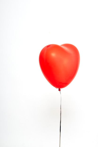 Foto globos de corazón rojo sobre un fondo blanco