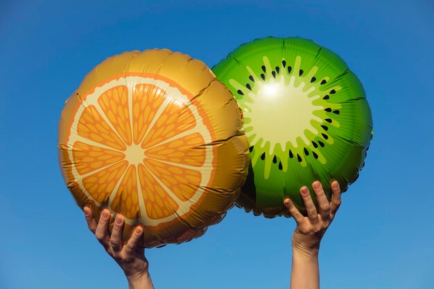 Globos de frutas de verano sostenidos en el aire contra un cielo azul brillante de verano