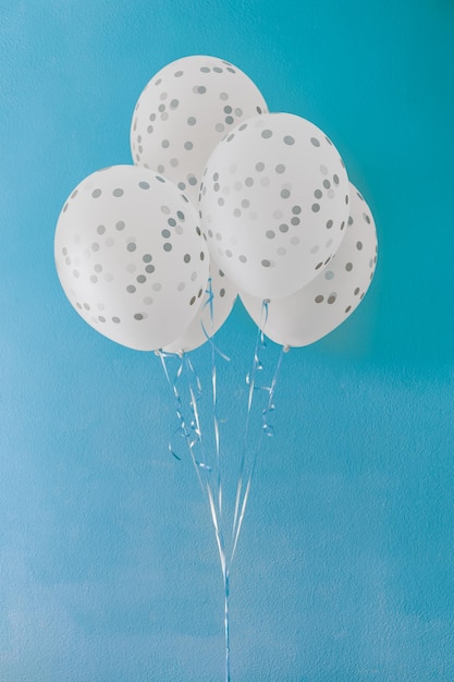 Globos de helio blanco con puntos grises sobre fondo azul varias vacaciones con manchas blancas y grises
