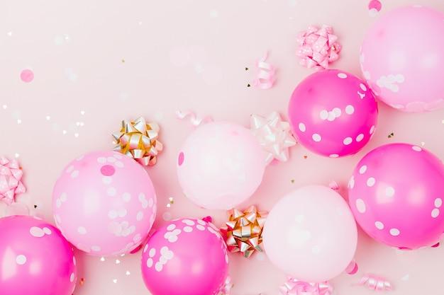 Globos rosas con confeti, lazos y adornos de papel. Tema de concepto de fiesta de cumpleaños. Endecha plana, vista superior