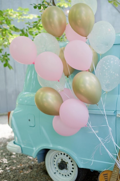 Globos rosas y dorados cerca de la autocaravana de menta Fiesta en colores pastel