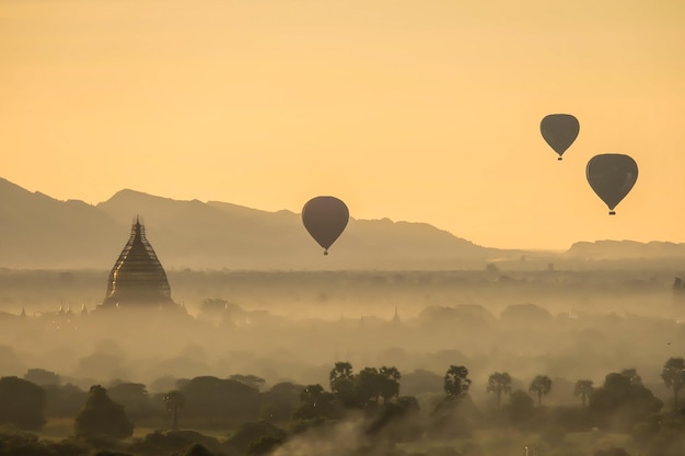 Los globos volaron sobre la pagoda en la niebla de la mañana en Bagan