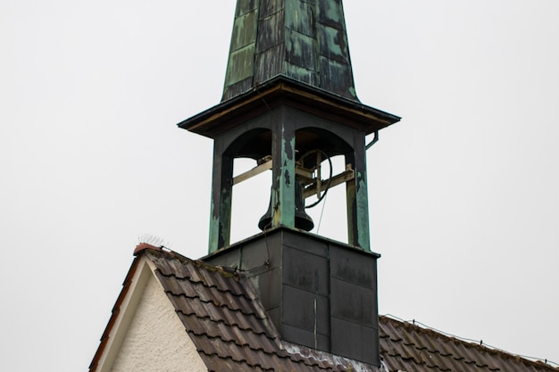 Glockenturm der katholischen Kirche gegen einen bewölkten Himmel.