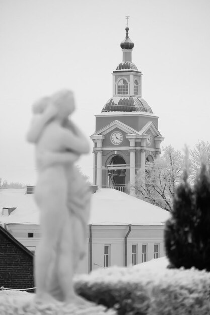 Foto glockenturm der verklärungskathedrale in der stadt wyborg im winter vor dem hintergrund von skulpturen