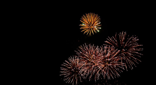 Glod e vermelho fogos de artifício brilham no céu da noite