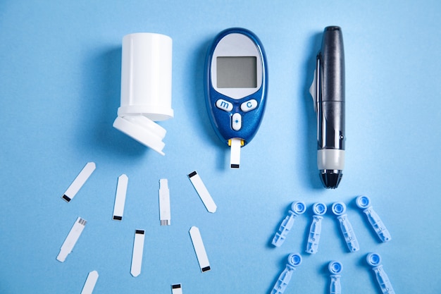 Glucômetro com tiras de teste e outros objetos médicos