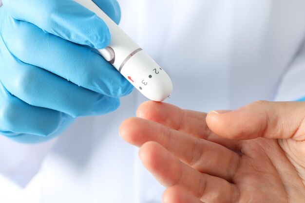 Glucómetro en la mano del médico y la mano femenina de cerca