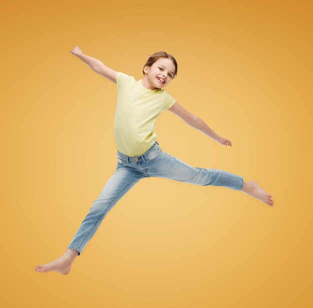 Glück, Aktivität und Kinderkonzept - lächelndes kleines Mädchen springt