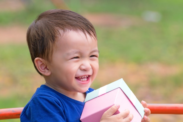 Glück des kleinen Jungen mit roter Geschenkbox