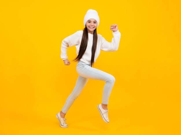 Glück, Freiheit, Bewegung und Kind Junges Teenager-Mädchen, das über gelben Hintergrund springt, lustiger Sprung