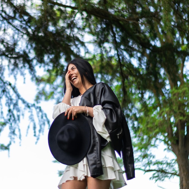 Glück im Park Lächelnde Frau, die den Moment mit einem Hut genießt