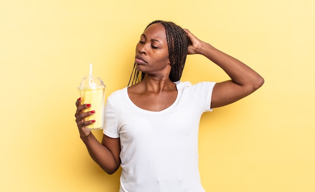 Glücklich lächelnd und träumend oder zweifelnd, zur Seite schauend. Milchshake-Konzept