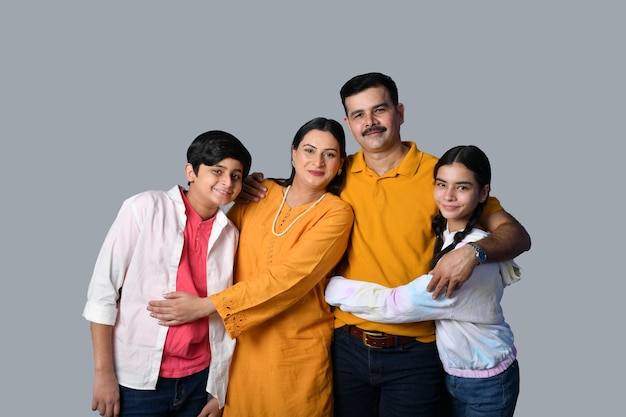 glücklich lächelnde junge Familie umarmt indisches pakistanisches Modell