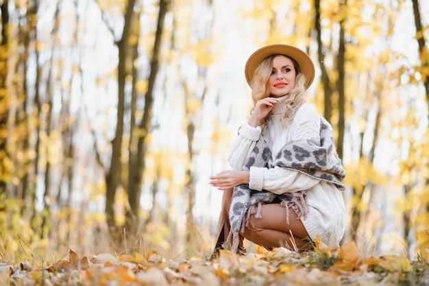 Glücklich lächelnde junge Frau im Park am Herbsttag