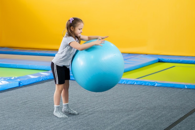 Glücklich lächelnde kleine Kinder, die auf Innen Trampolin im Unterhaltungszentrum springen