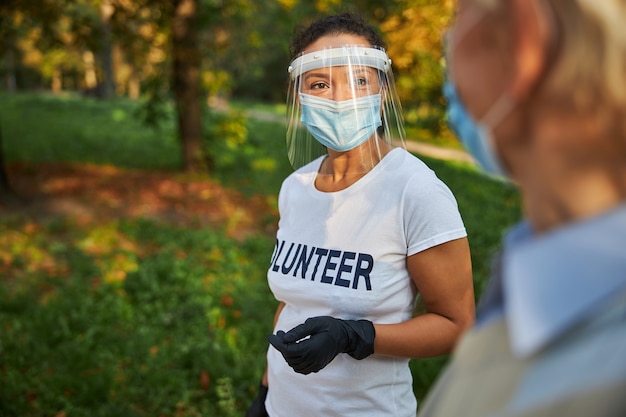 Glücklich lächelnde Sozialarbeiterin im Gespräch mit älteren Männern im Freien