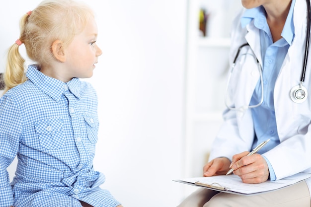 Glücklich lächelnder Kinderpatient bei der üblichen ärztlichen Untersuchung. Arzt und Patient in der Klinik. Medizin, Gesundheitskonzepte.