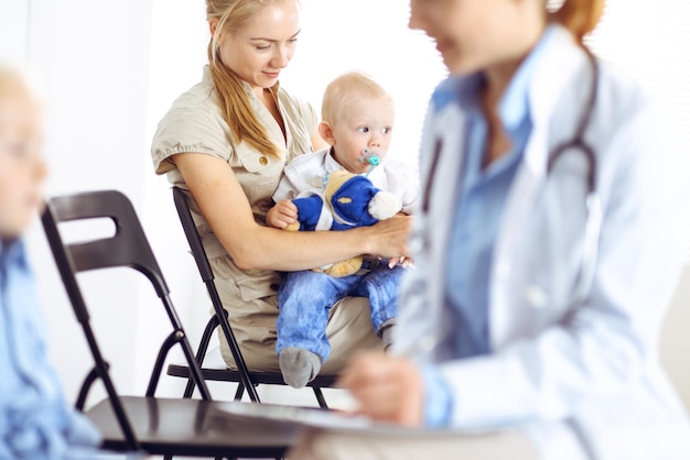 Foto glücklich lächelnder kinderpatient bei der üblichen ärztlichen untersuchung. arzt und patient in der klinik. medizin, gesundheitskonzepte.