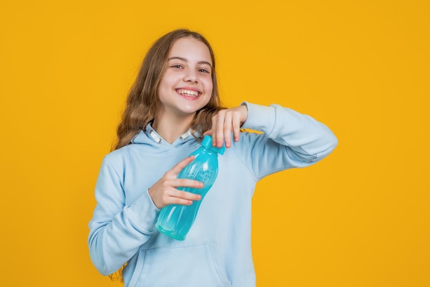 Glücklich lächelndes Kind Mädchen halten Wasserflasche zum Trinken nach dem Sporttraining Wasserhaushalt