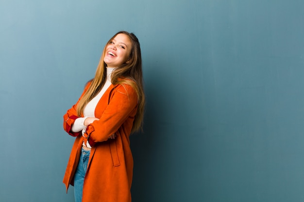 glücklich mit verschränkten Armen lachen, mit einer entspannten, positiven und zufriedenen Pose