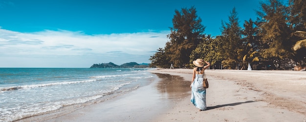 Glücklich reisende asiatische Frau mit weißem Kleid, die sich abends am Strand von Thailand entspannt, Vintage-Stil