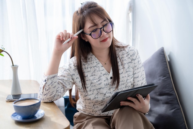 Glücklich über asiatische freiberufliche Geschäftsfrauen, die lässig mit Draw arbeiten oder digitale Notizen machen